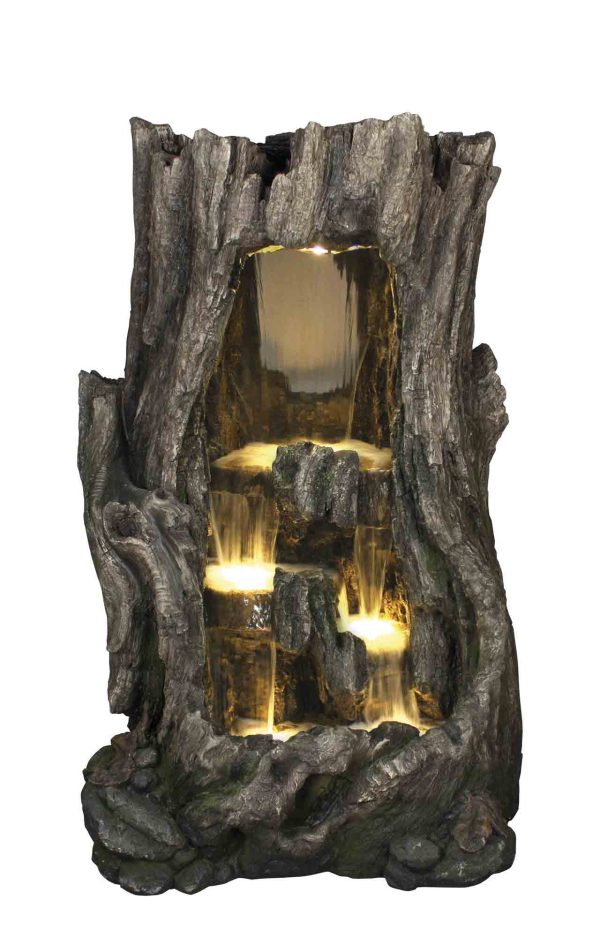 Water feature is a tall hollowed aged tree trunk with internal tiers that water flows down. Each basin is backlit.